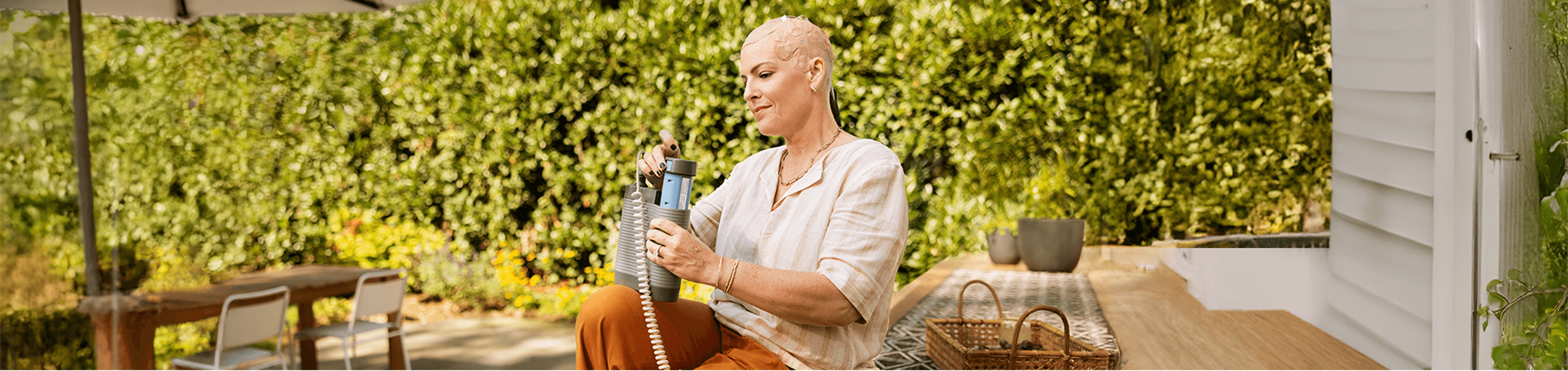 Ryann in a garden while using her Optune Gio.